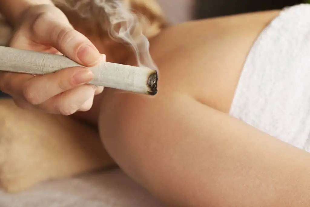 Bâton de moxa diffusant sa chaleur au-dessus de la jambe