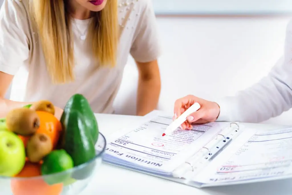 Échange autour d’un dossier nutritionnel avec un panier de fruits frais